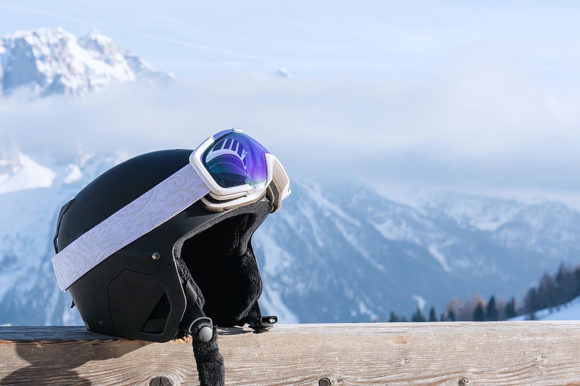 View of ski helmet with sunglasses on the background of snow-capped mountains. Landscape, industry